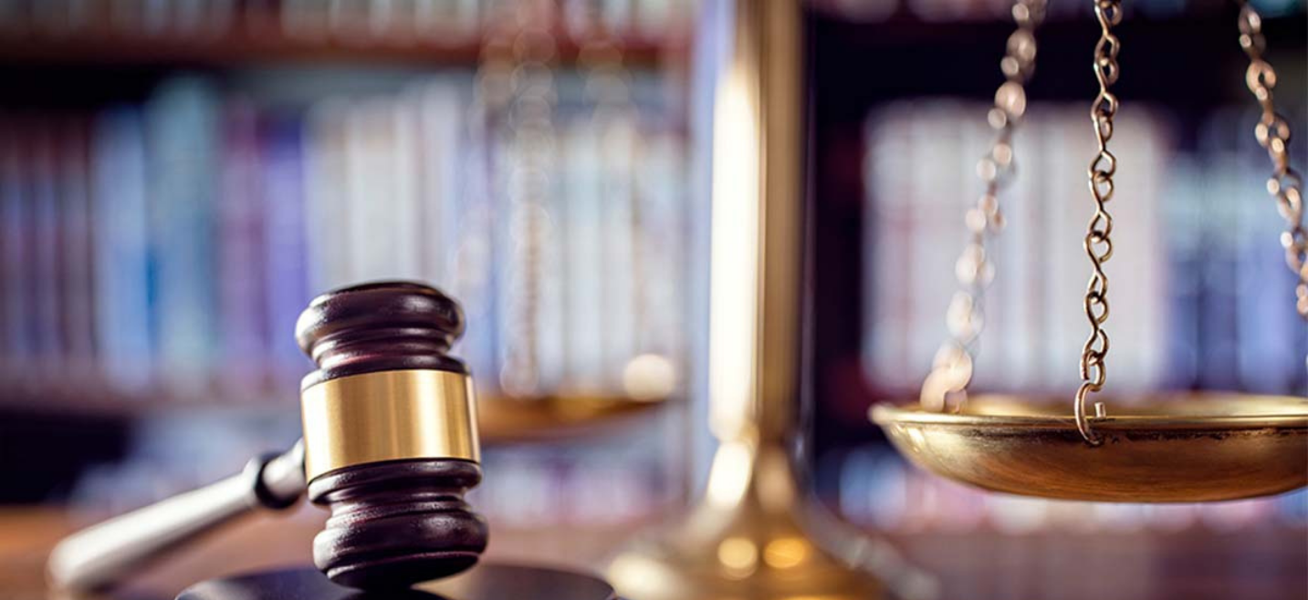 Gavel and scale resting on desk