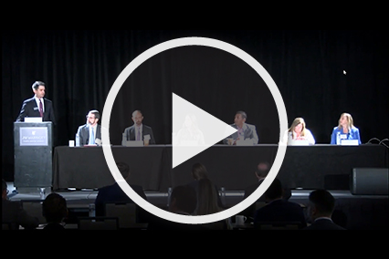 Panelists sitting at table in front of black curtain