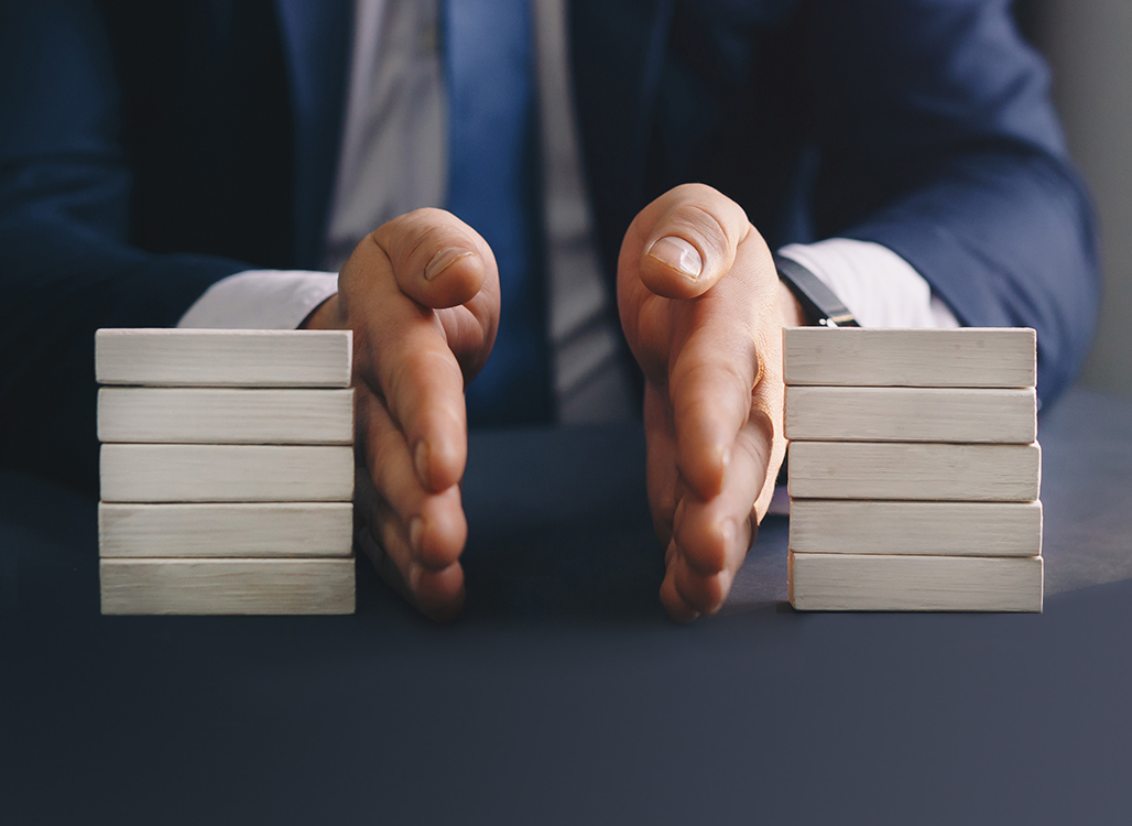 Two hands separating two stacks of white blocks